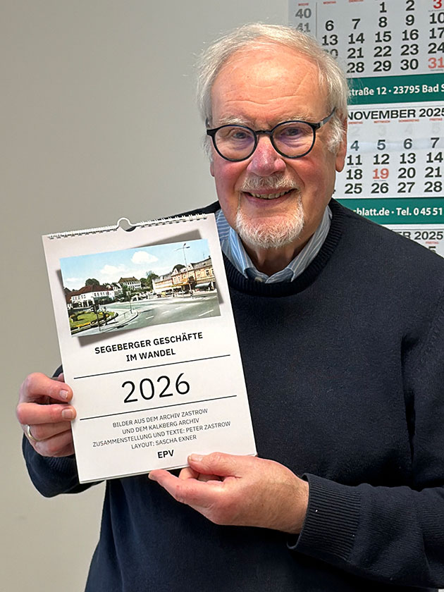 Mann hält Kalender für 2026 mit historischem Foto.