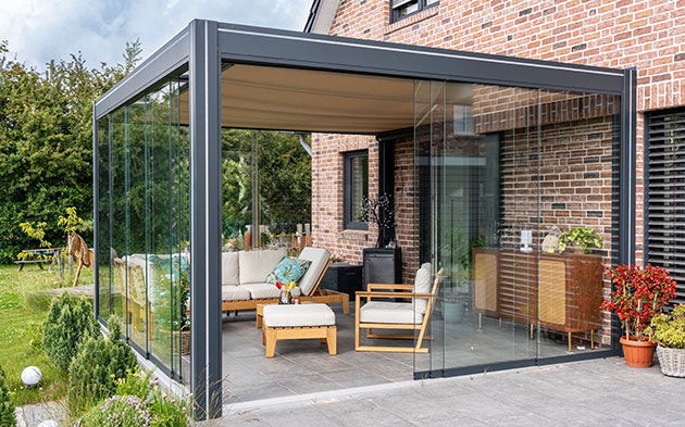 Moderner Wintergarten mit Glaswänden und gemütlicher Einrichtung