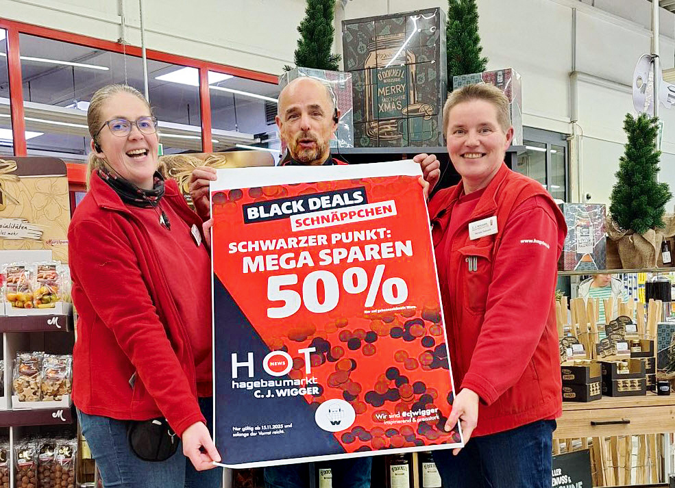 Drei Personen halten ein 50%-Rabatt-Schild im Baumarkt.