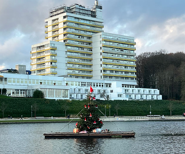 Weihnachtsbaum auf dem Segeberger See vor Gebäude