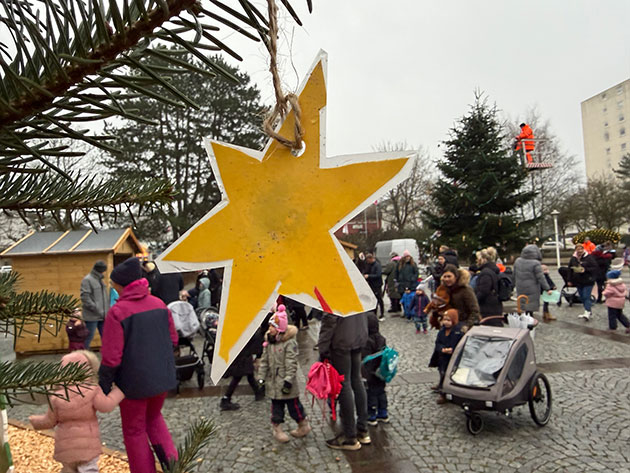 Weihnachtsbaum in Trappenkamp mit gelbem Stern und Menschen