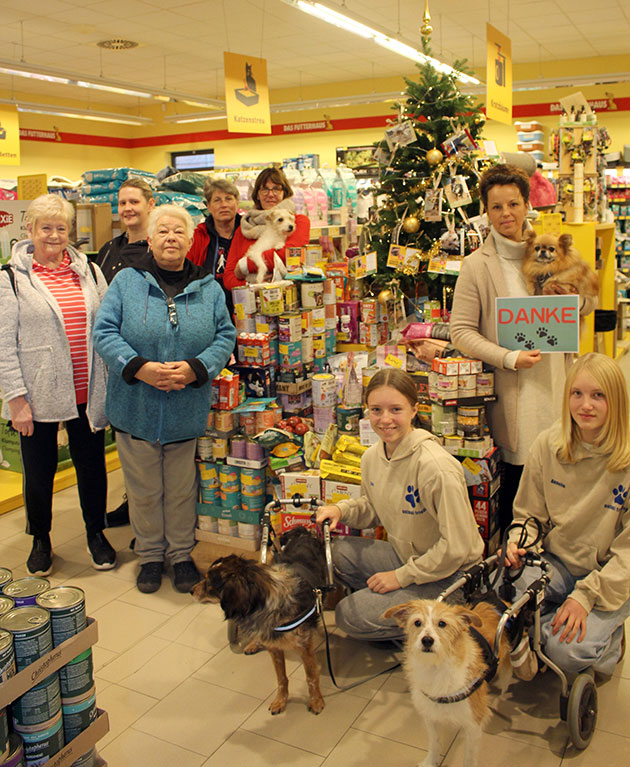 Gruppenfoto in einem Tierbedarfsgeschäft mit Spendenstapel.