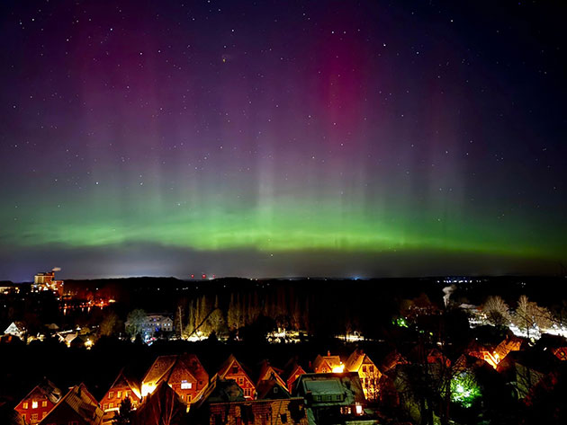 Nordlichter über einer Stadt bei Nacht