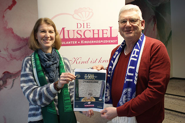 Zwei Menschen halten ein Spendenzertifikat.