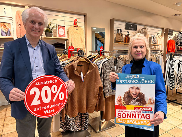 Zwei Personen präsentieren Rabatt im Bekleidungsgeschäft.