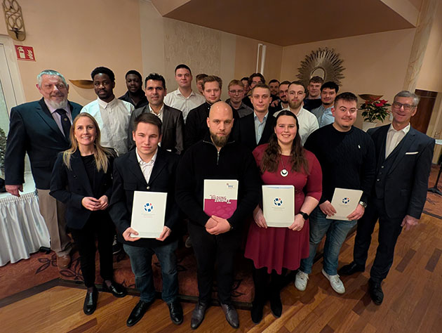 Gruppe von Menschen mit Urkunden posiert bei Veranstaltung.