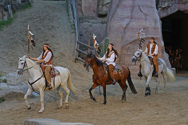 Drei Reiter in Kostümen auf Pferden im Freilichttheater.