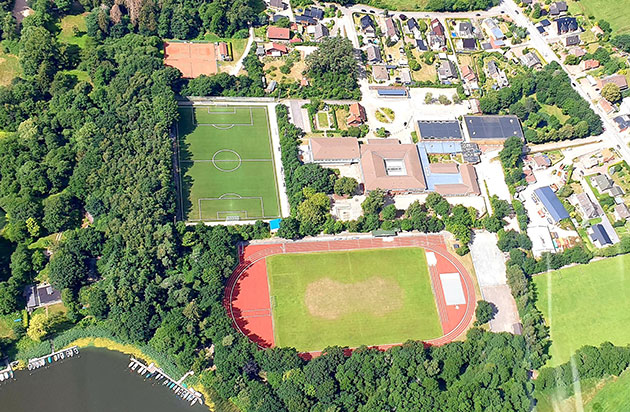 Luftbild eines Sportkomplexes mit Fußballplatz und Laufbahn