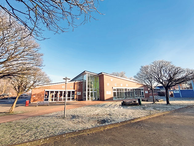 Modernes Gebäude mit Bäumen und blauem Himmel.