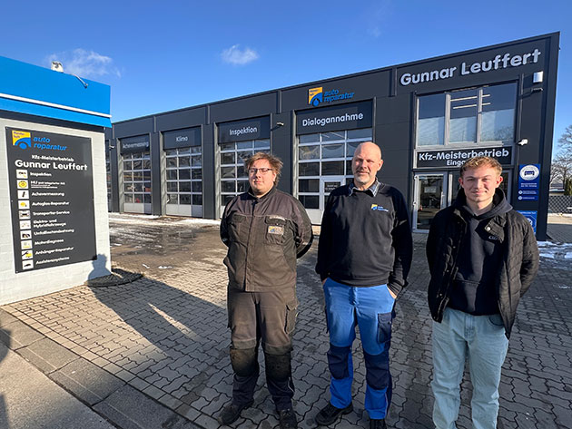 Drei Männer stehen vor einer Autowerkstatt Gunnar Leuffert.