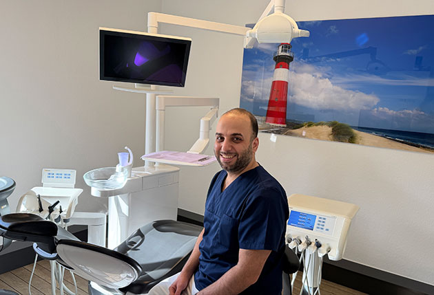 Zahnarzt im Behandlungsraum mit Leuchtturmbild