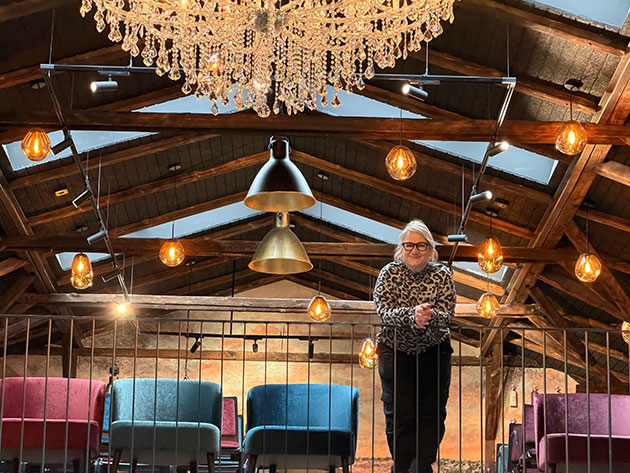 Frau im Raum mit Kronleuchter und gemütlicher Beleuchtung.