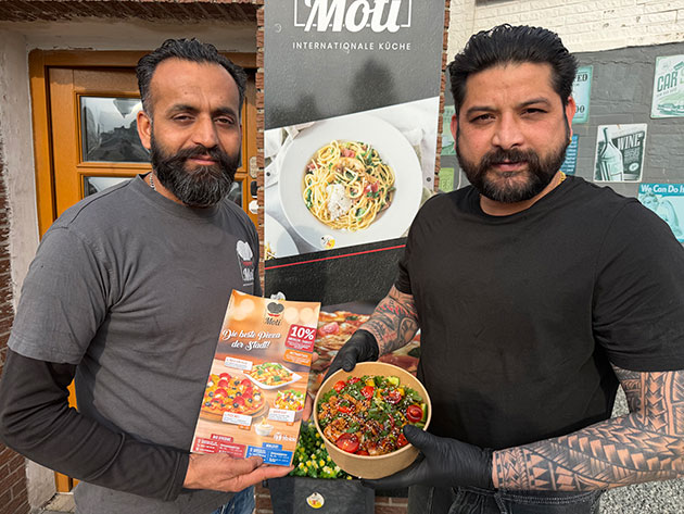 Zwei Männer präsentieren Speisekarte und Bowl.