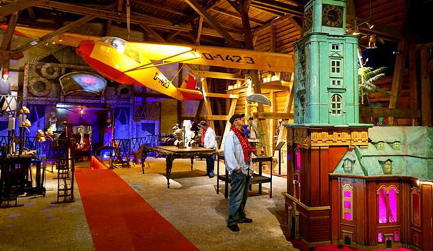 Innenraum mit Flugzeug, Turm und Besucher in einer Ausstellung.