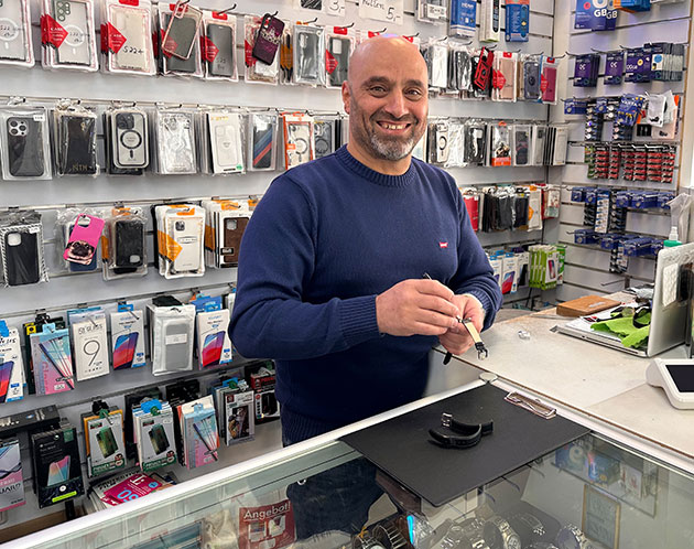 Mann mit Kabel in einem Handygeschäft.