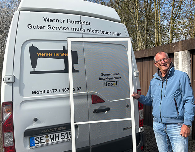 Mann steht neben Lieferwagen mit Insektenschutztür.