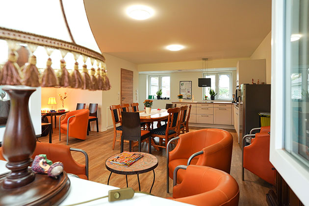 Gemütlicher Wohnraum mit Esstisch und Ledersesseln.