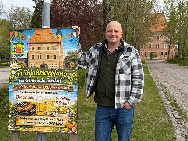 Mann steht neben Plakat für Frühjahrsfest in Seedorf.