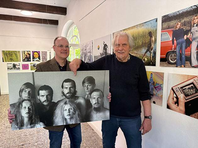 Zwei Männer halten ein altes Schwarz-Weiß-Foto.
