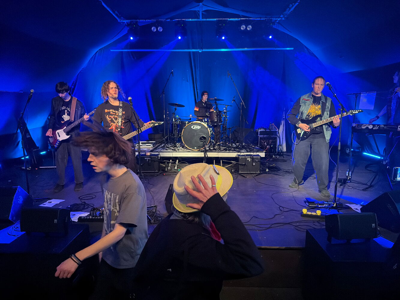 Band spielt live auf der Bühne mit blauem Licht.