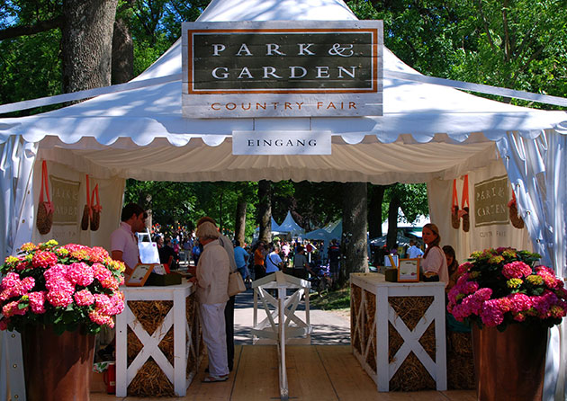 Eingangszelt zur Park & Garden Country Fair, geschmückt mit Blumen.