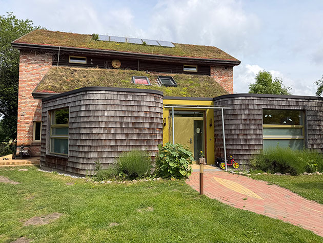 Ökohaus mit begrüntem Dach und Solarmodulen.
