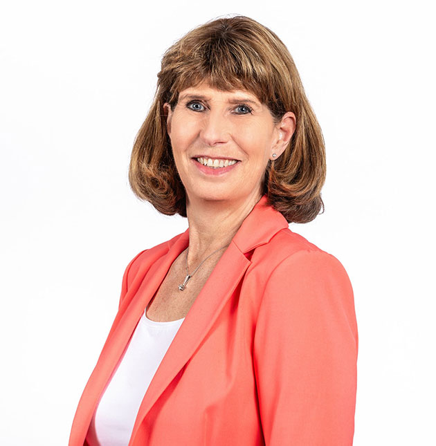 Frau in korallfarbenem Blazer vor weißem Hintergrund