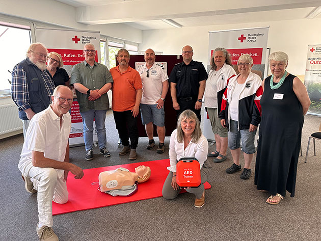 Gruppe bei Erste-Hilfe-Training mit einem AED-Trainer.