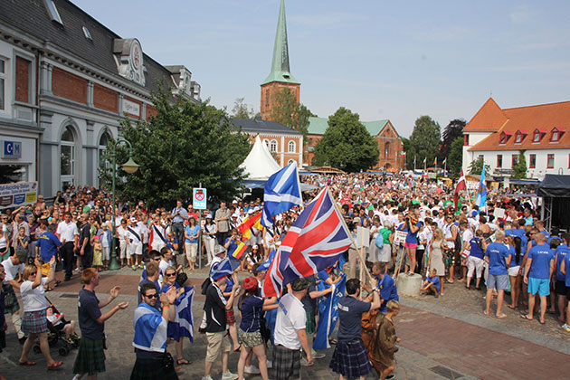Menschenmenge mit Flaggen auf einem Stadtplatz
