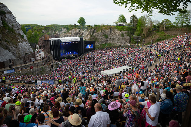 Großes Publikum bei einem Open-Air-Konzert in einer Felsarena.