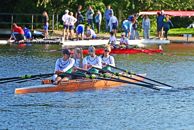 Vierköpfige Rudermannschaft im Wettbewerb auf dem Wasser.