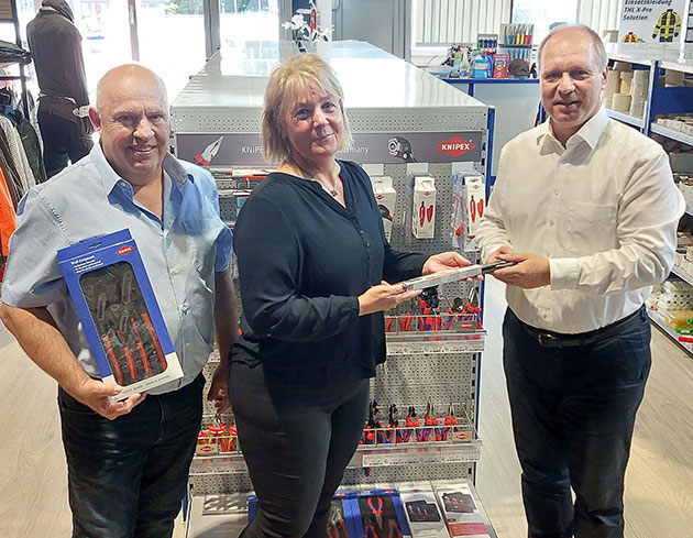 Drei Personen mit Werkzeugen in einem Geschäft.