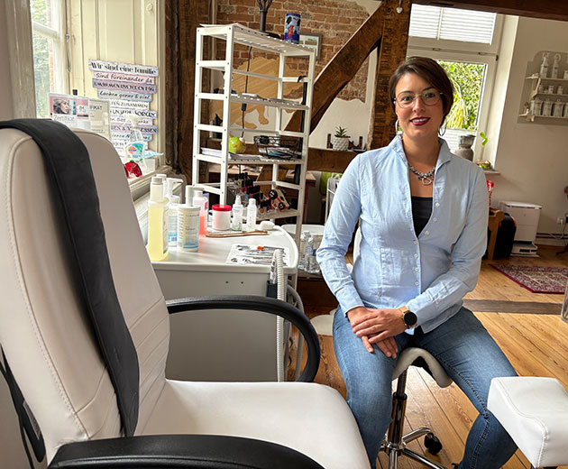 Frau sitzt in einem Schönheitsstudio auf einem Stuhl.