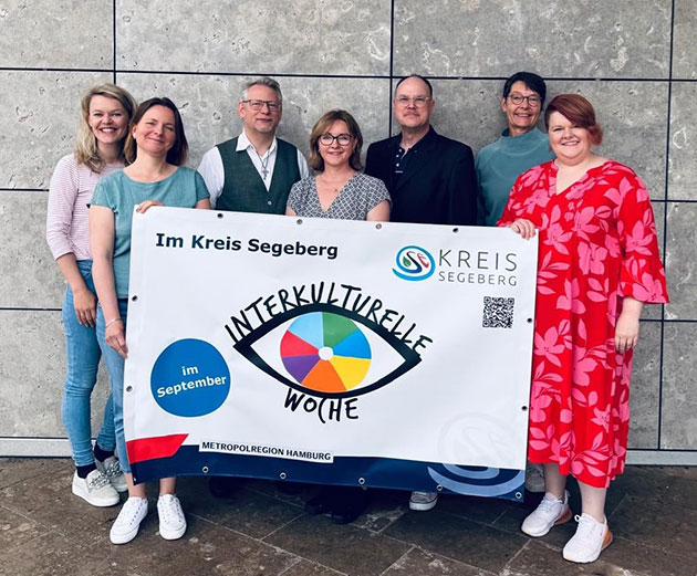 Gruppe posiert mit Banner zur Interkulturellen Woche.
