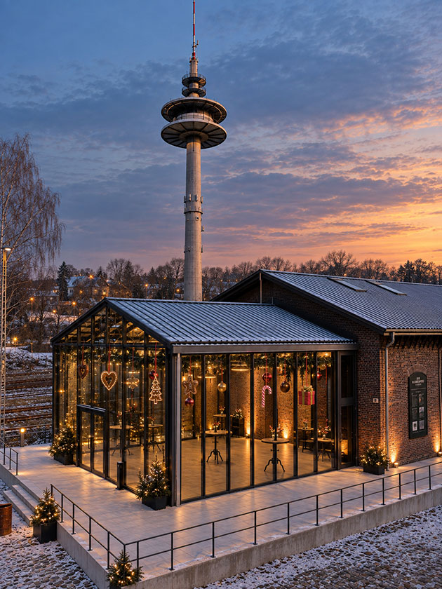 Winterliche Halle mit Turm bei Sonnenuntergang.