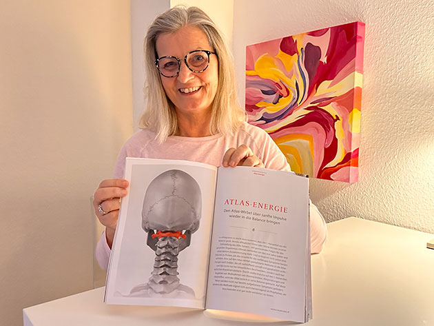 Frau zeigt offenes Buch über Atlas-Energie in Praxis.