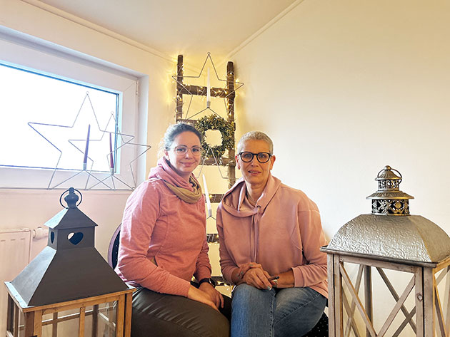 Zwei Frauen sitzen in einem dekorativen Raum mit Laternen.