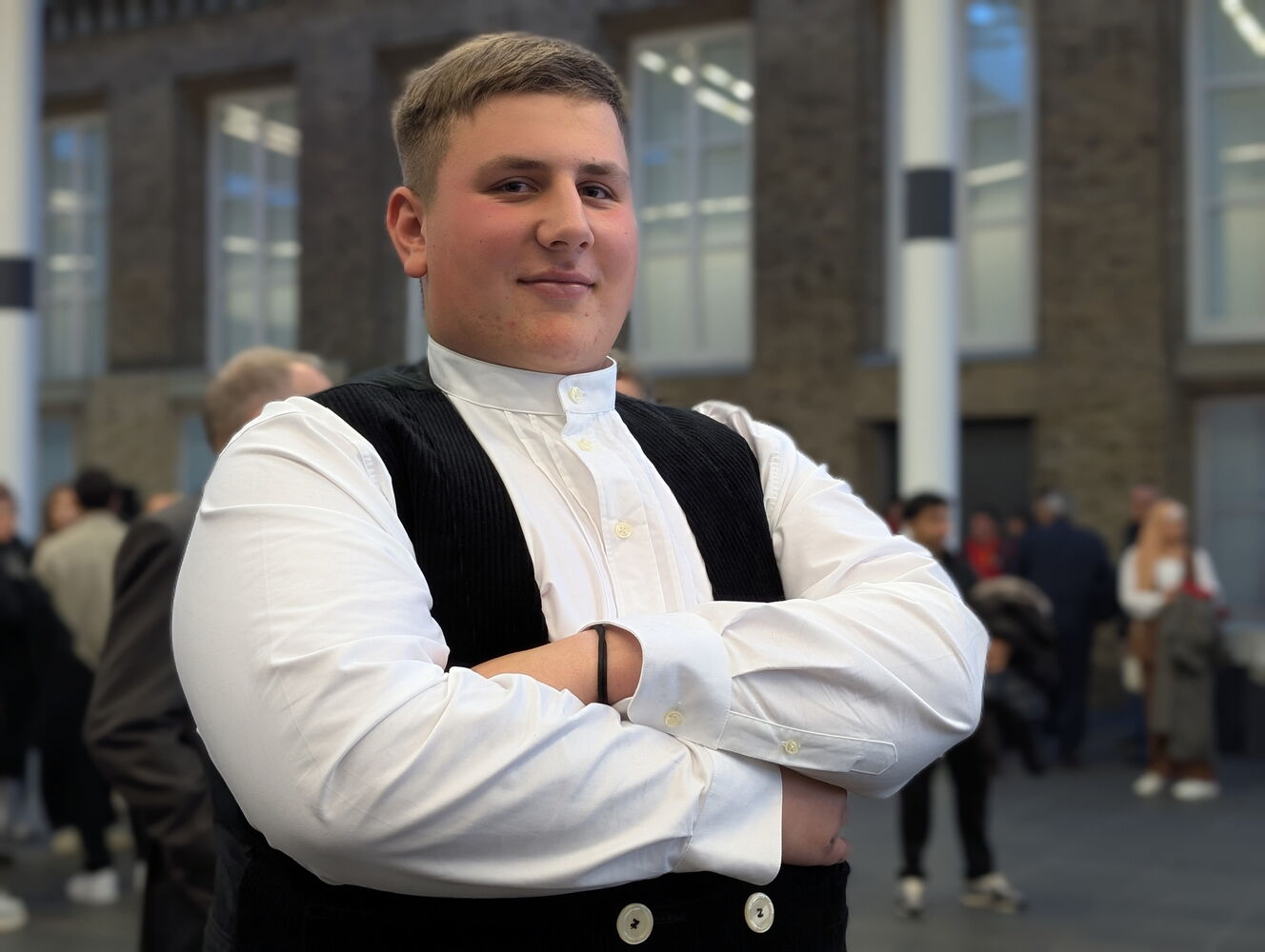 Junger Mann in traditioneller Kleidung bei einer Veranstaltung.