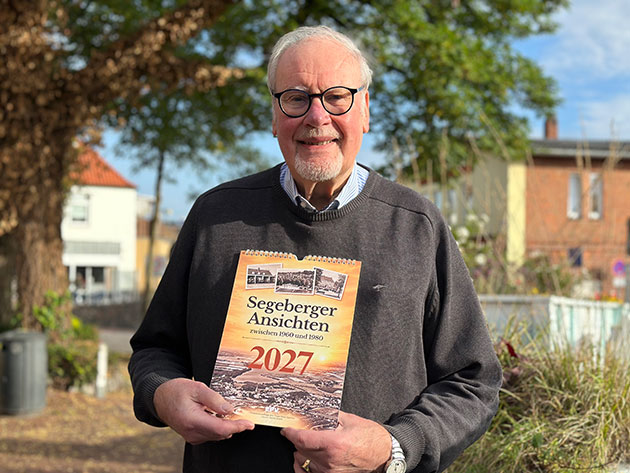 Mann mit Kalender 'Segeberger Ansichten 2027' in der Hand.