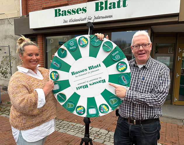 Zwei Personen mit Glücksrad vor Basses Blatt.