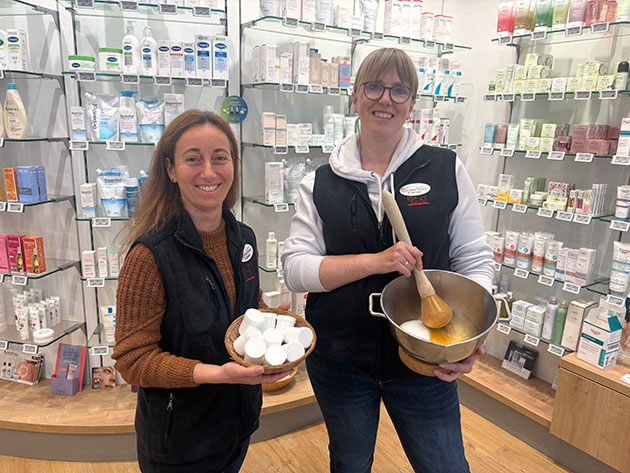 Zwei Frauen mit Schalen in einer Drogerie vor Produkten.