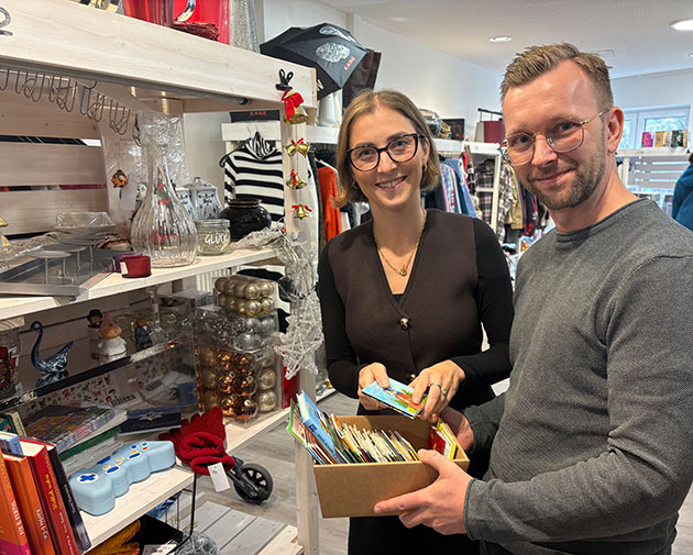Zwei Menschen mit Kartenbox in einem Dekoladen.