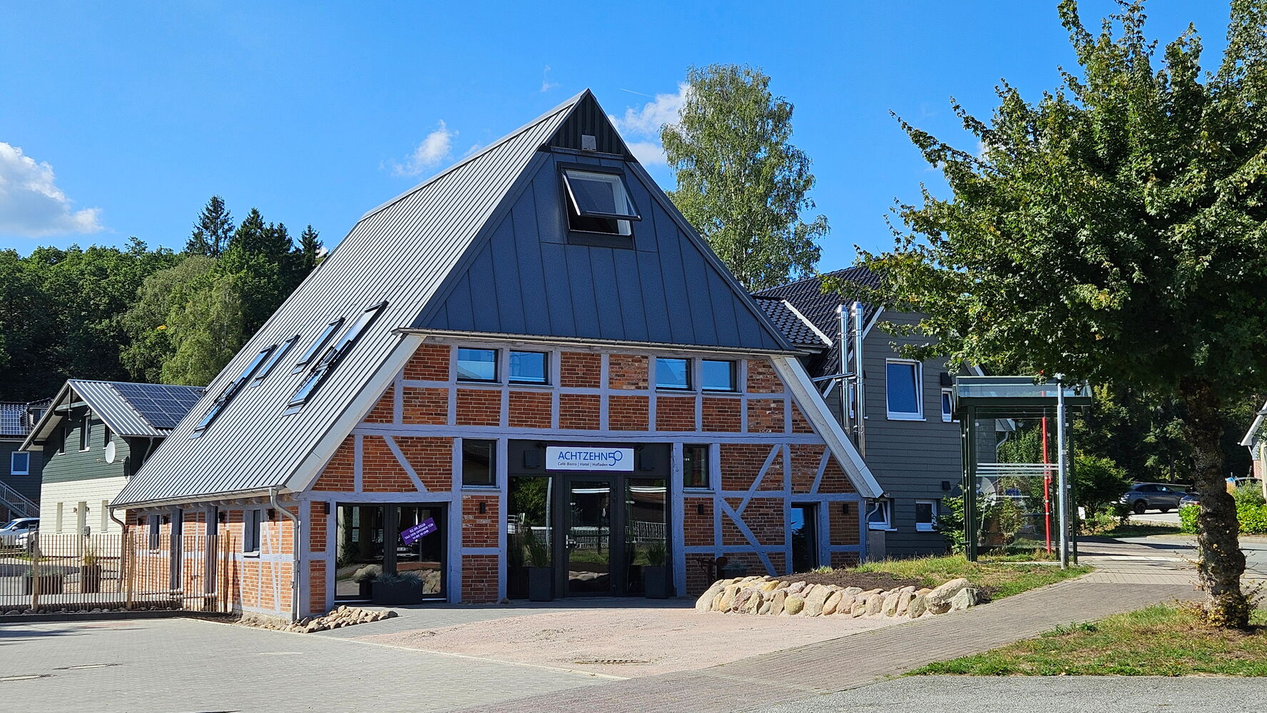 Modernes Fachwerkhaus mit Glasfassade bei Sonnenschein.
